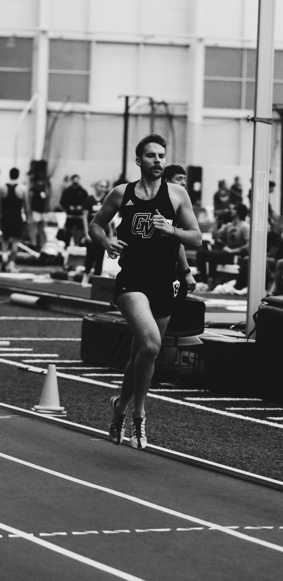 black and white photo of a male identifying track athlete competing in a race.